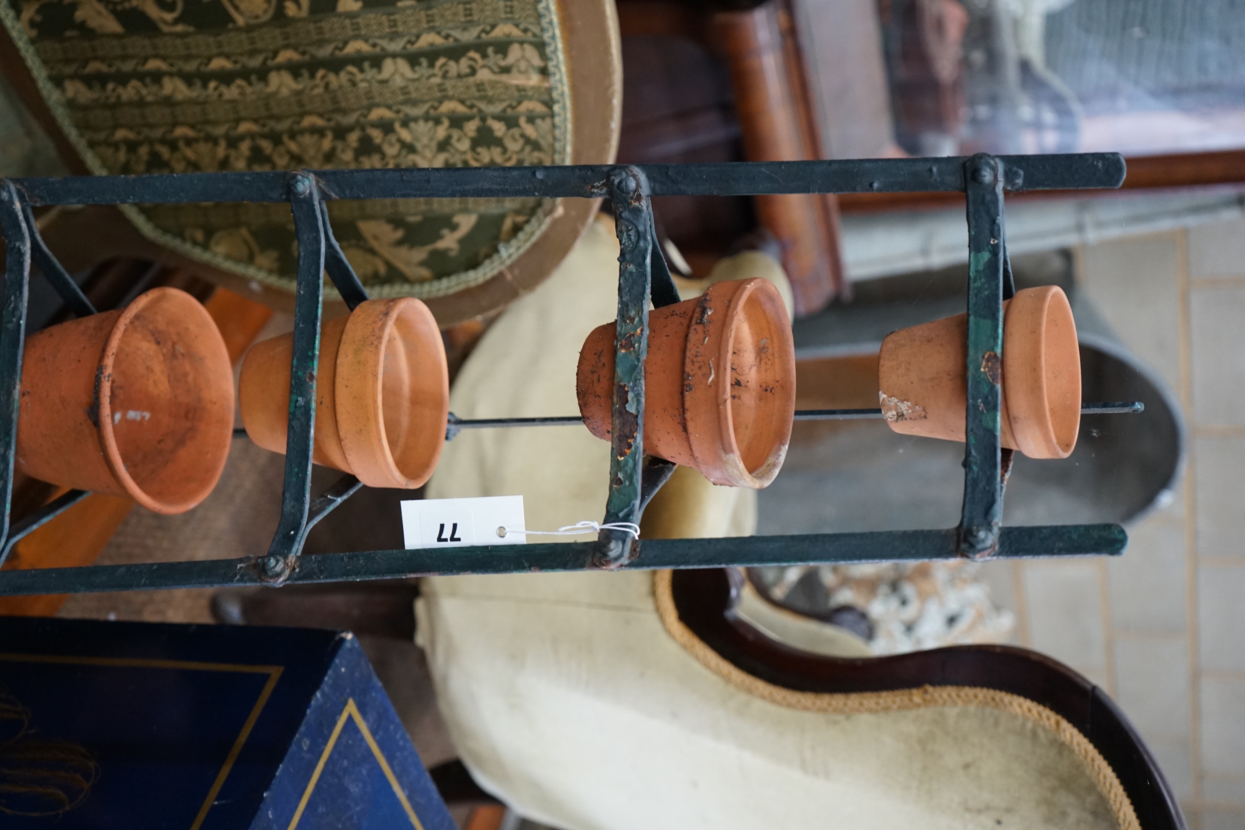 A wrought iron six tier pot stand, together with six terracotta pots, height 143cm